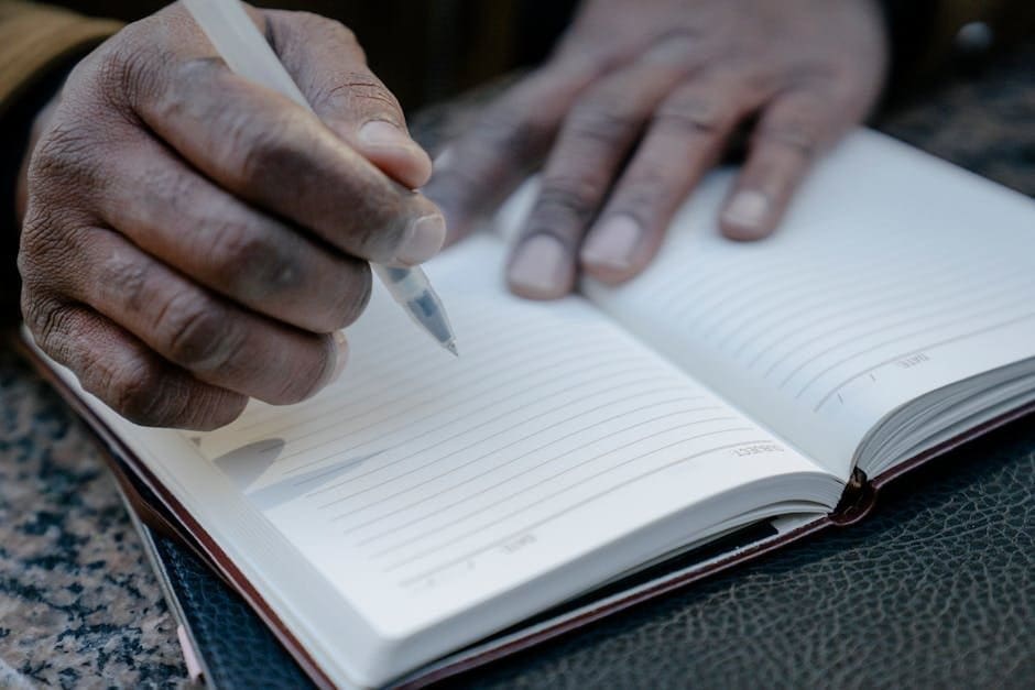 Person writing an opening line in a notebook